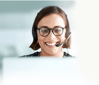 A close-up of a woman’s face, smiling and speaking into a headset.