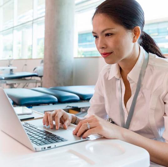 A business woman is concentrating on her work while using a computer.
